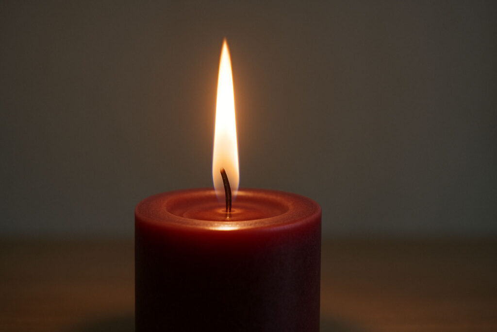 Sharp candle flame glowing brightly with blurred surroundings for focus